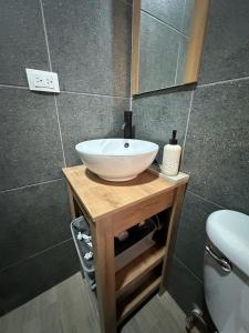 a bathroom with a white sink on a wooden table at Apartment D Fuertevali in San Salvador