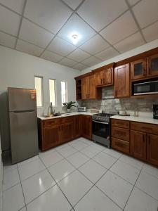 a kitchen with wooden cabinets and a stainless steel refrigerator at Apartment D Fuertevali in San Salvador