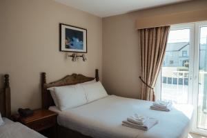 a hotel room with two beds and a window at Lehinch Lodge in Lahinch