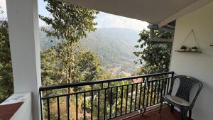 a balcony with a chair and a view of a mountain at Chotlung BNB in Bijanbāri Bāzār