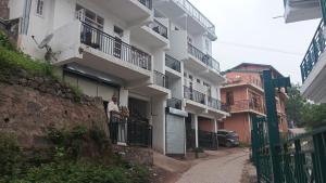 a man standing on a balcony of a building at Dhananjay home stay in Dharampur +10 photos