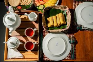 a table topped with plates and cups of tea at AnuBi Nest Ella in Ella
