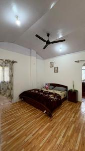 a bedroom with a bed on a wooden floor at Chotlung BNB in Bijanbāri Bāzār