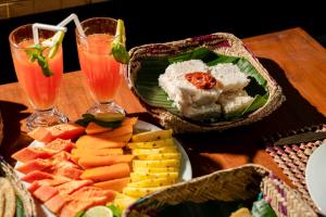 a plate of food on a table with two drinks at AnuBi Nest Ella in Ella +23 photos
