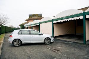 a white car parked in front of a building at Hotel Maxim in Peschiera Borromeo