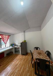 a living room with a table and a kitchen at Chotlung BNB in Bijanbāri Bāzār