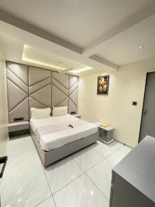 a large white bedroom with a large bed in it at Hotel Skyland in Ahmedabad