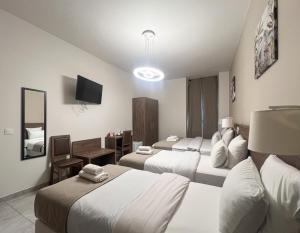 a hotel room with two beds and a desk at SQUARE HOTEL in Nîmes