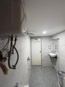 a bathroom with a white door and a sink at Hotel Skyland in Ahmedabad