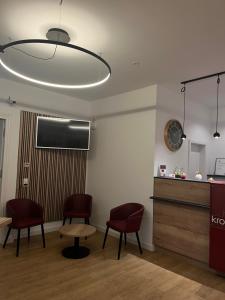 a waiting room with two chairs and a table and a clock at Hotel Kronprinz Garni in Minden