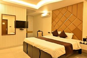 a bedroom with a large bed and a mirror at Hotel Rajmahal Regency in Faridabad