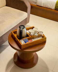 a wooden tray with a tea kettle on a table next to a bed at New Crown Plaza in Jodhpur