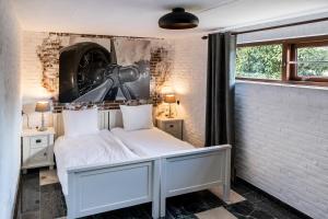 a bedroom with a white bed and a brick wall at Bij nr 5 Teuge in Terwolde
