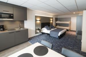 ein Hotelzimmer mit Bett und Küche in der Unterkunft Hotel Edenpark in Brunssum