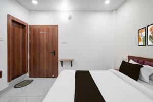 a bedroom with a bed and a wooden door at Hotel O Royal Krishna in Gorakhpur