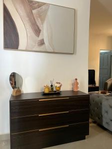 a dresser in a living room with a painting on the wall at Bungo Home - Suite Chambre & salon à 2 min de la plage in Pointe-Noire