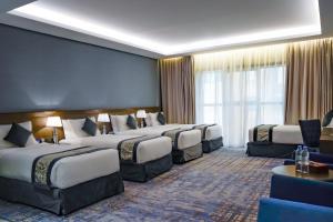 a hotel room with four beds in a row at Maien Taiba in Medina