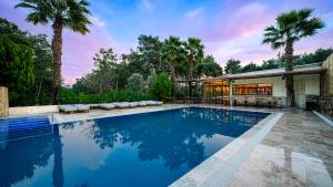 a swimming pool in front of a house at Garrya Romo Hotel in Urla