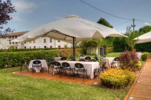 a wooden deck with tables and chairs under a large umbrella at Locanda Veneta in Vicenza