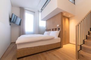 a bedroom with a bed and a tv and stairs at Suite Apartments by Hotel Gabbani in Lugano