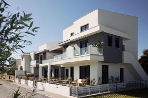 a white building with balconies on a street at Thalassa & Thalassa Prive Residential Complex in Ofrínion
