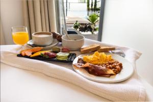 a breakfast plate of food and a glass of orange juice at Hotel Santa Eulália Bay - Adults Only in Albufeira