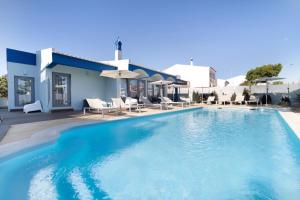 a swimming pool in front of a villa at Hotel Santa Eulália Bay - Adults Only in Albufeira