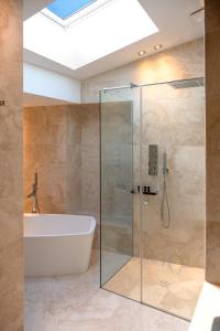 a bathroom with a tub and a glass shower stall at Suite Apartments by Hotel Gabbani in Lugano
