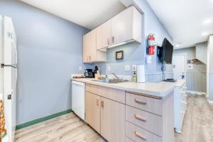 a kitchen with white cabinets and a sink at Sea Treasures Inn #104 in Rockaway Beach