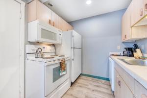 a kitchen with white appliances and a white refrigerator at Sea Treasures Inn #104 in Rockaway Beach