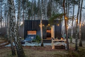 a tiny house in the woods with a table and chairs at Hidden Base - romantyczna leśna kryjówka in Smolarnia +17 photos