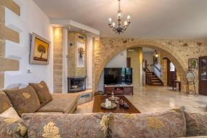 a living room with a couch and a tv at Villa Chrysseva in Plátanos