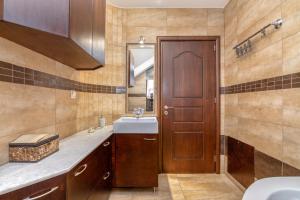 a bathroom with a sink and a wooden door at Villa Chrysseva in Plátanos +34 photos