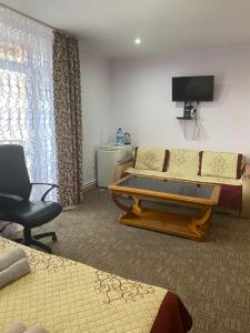 a hotel room with a bed and a desk and a chair at Вілла Верховина in Skhidnitsa
