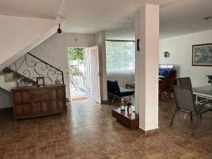 a living room with a table and chairs and a dining room at The Cats Nail house in Cali