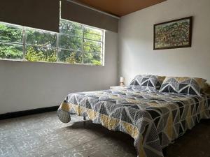 a bedroom with a bed and two windows at The Cats Nail house in Cali