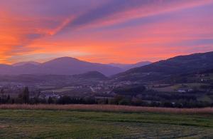 a sunset over a field with mountains in the background at Dazumahl schafft besondere Augenblicke für Genießer im naturnahen Private Hideaway in der Oststeiermark in Puch bei Weiz