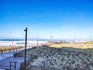 a sandy beach with a bench and the ocean at Apartment Horizon Marin-2 by Interhome in Lacanau-Océan