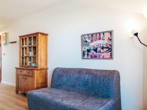 a living room with a blue chair and a cabinet at Apartment Horizon Marin-2 by Interhome in Lacanau-Océan