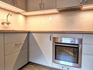 a kitchen with white cabinets and an oven at Holiday Home Ötztal by Interhome in Oetz +26 photos