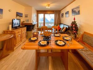 a living room with a table and a christmas tree at Apartment Hauts de Nendaz BI3 by Interhome in Nendaz +26 photos