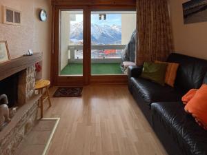 a living room with a couch and a large window at Apartment Hauts de Nendaz BI3 by Interhome in Nendaz