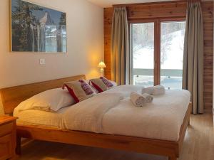 a bedroom with a large bed with towels on it at Apartment Hauts de Nendaz BI3 by Interhome in Nendaz