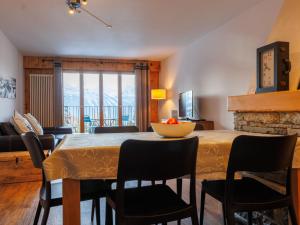 a dining room with a table and chairs and a living room at Apartment Chaedoz 24-1 by Interhome in Nendaz