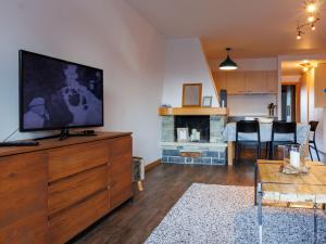 a living room with a flat screen tv on a dresser at Apartment Chaedoz 24-1 by Interhome in Nendaz