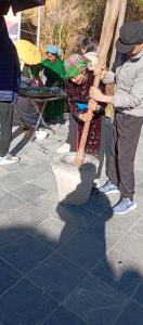 a young girl is holding a large wooden stick at Hoàng Thông Homestay in Mia Si