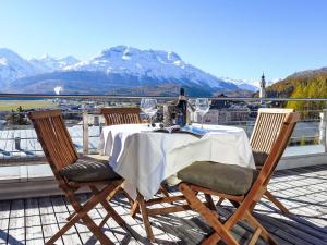 a table and chairs on a balcony with a mountain at Apartment Chesa Crusch 7 by Interhome in Samedan