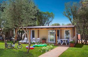 a house with a table and chairs in a yard at Maistra Camping Polari Mobile homes in Rovinj