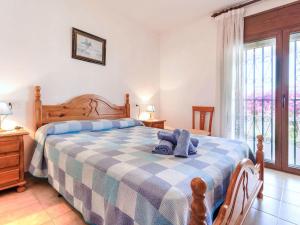 a bedroom with a bed with a blue and white blanket at Villa Villa Mar by Interhome in Miami Platja
