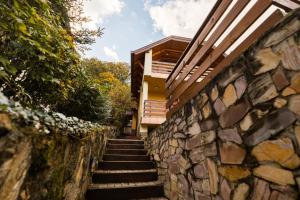 a stone wall with stairs leading up to a house at Noszvaj Elite Apartman in Noszvaj